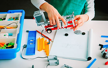 Boy building robotic vehicles with Lego bricks